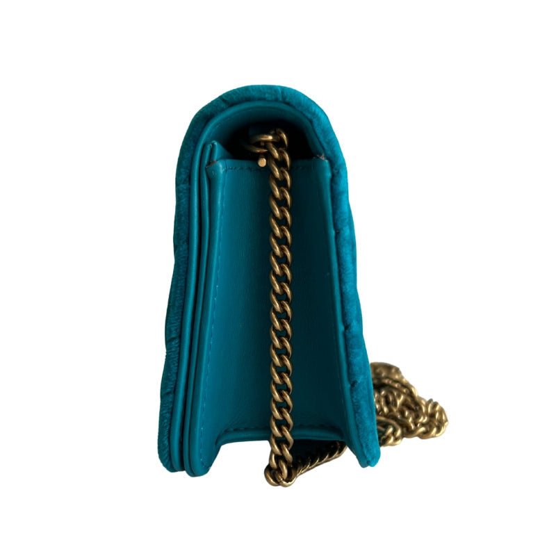 Side view: Gucci GG Marmont Velvet Crossbody Bag. Teal Velvet .Gold Toned Hardware. Pink Canvas Lining. Snap Closure at Front. 