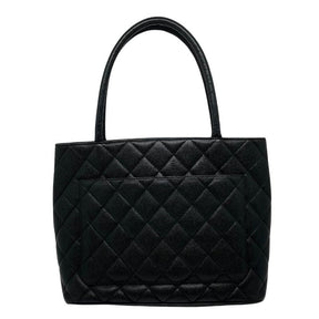 Chanel caviar medallion tote, black quilted caviar leather exterior, rolled dual handles, large cc logo at front, exterior pocket on back, silver hardware, top zip closure, dual interior pockets, leather lining, back view