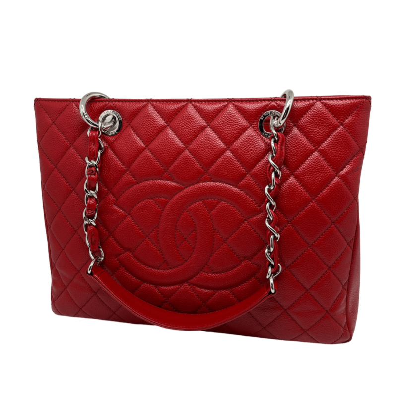 Chanel Grand Shopping Tote in quilted red caviar leather with chain link shoulder strap, interlocking CC logo, single exterior pocket, three interior pockets, and open top. Like new condition