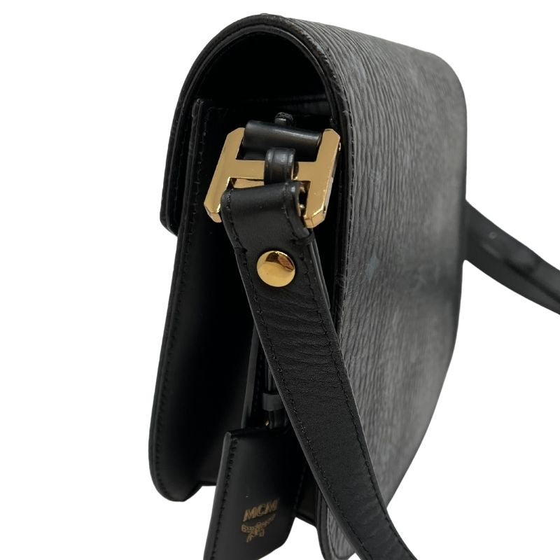 MCM Crossbody Bag with black and grey logo print, gold tone hardware, single adjustable shoulder strap, push lock closure, and interior zippered pocket. Great condition