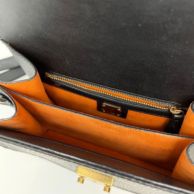 MCM Crossbody Bag with black and grey logo print, gold tone hardware, single adjustable shoulder strap, push lock closure, and interior zippered pocket. Great condition