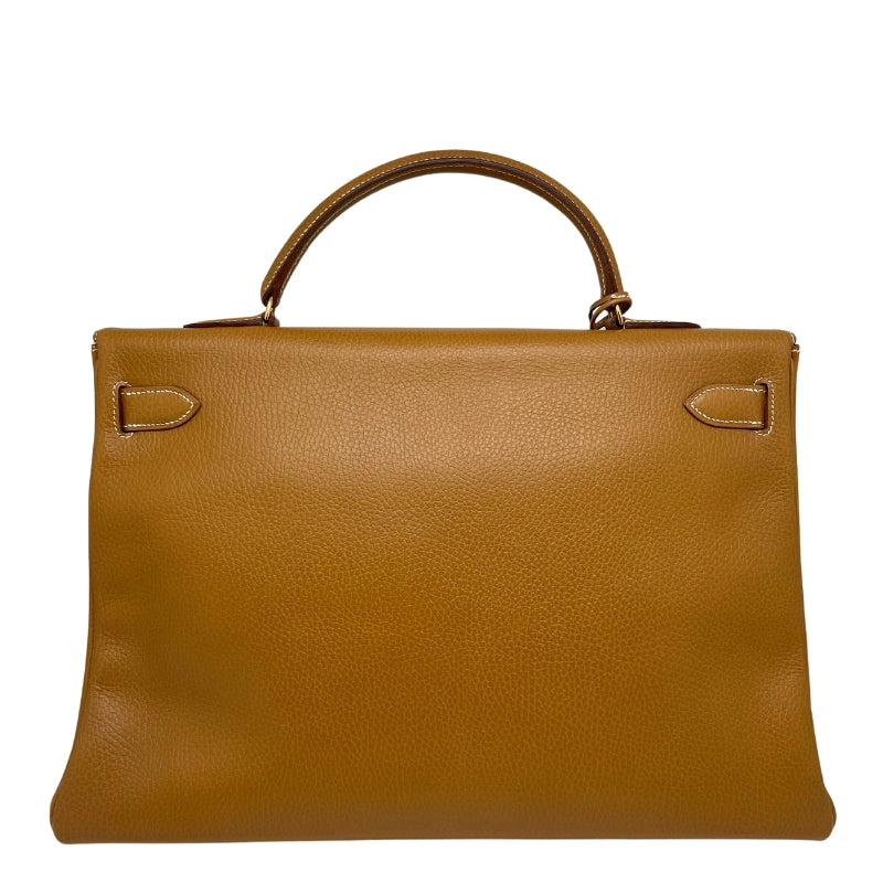 Hermès Ardennes Kelly Retourne 35  Top Handle Bag  Gold Ardennes Leather  Gold-Plated Hardware  Front Turn-Lock Closure  Protective Feet  Includes Lock, Keys & Clochette  Chevre Goatskin Interior  Two Interior Flat Pockets   One Interior Zipper Pocket  Dust Bag Included