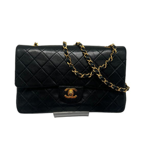 Chanel Double Flap Quilted Shoulder Bag  Black Leather Exterior  Gold Toned Hardware  Gold-Toned Chain-link Shoulder Strap  Single Exterior Back Pocket with Burgundy Leather Interior  Single Black Zipper Under First Flap  Burgundy Chanel Logo Under Second Flap  Three Interior Flat Pockets Under Second Flap