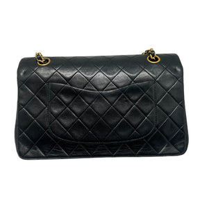 Chanel Double Flap Quilted Shoulder Bag  Black Leather Exterior  Gold Toned Hardware  Gold-Toned Chain-link Shoulder Strap  Single Exterior Back Pocket with Burgundy Leather Interior  Single Black Zipper Under First Flap  Burgundy Chanel Logo Under Second Flap  Three Interior Flat Pockets Under Second Flap