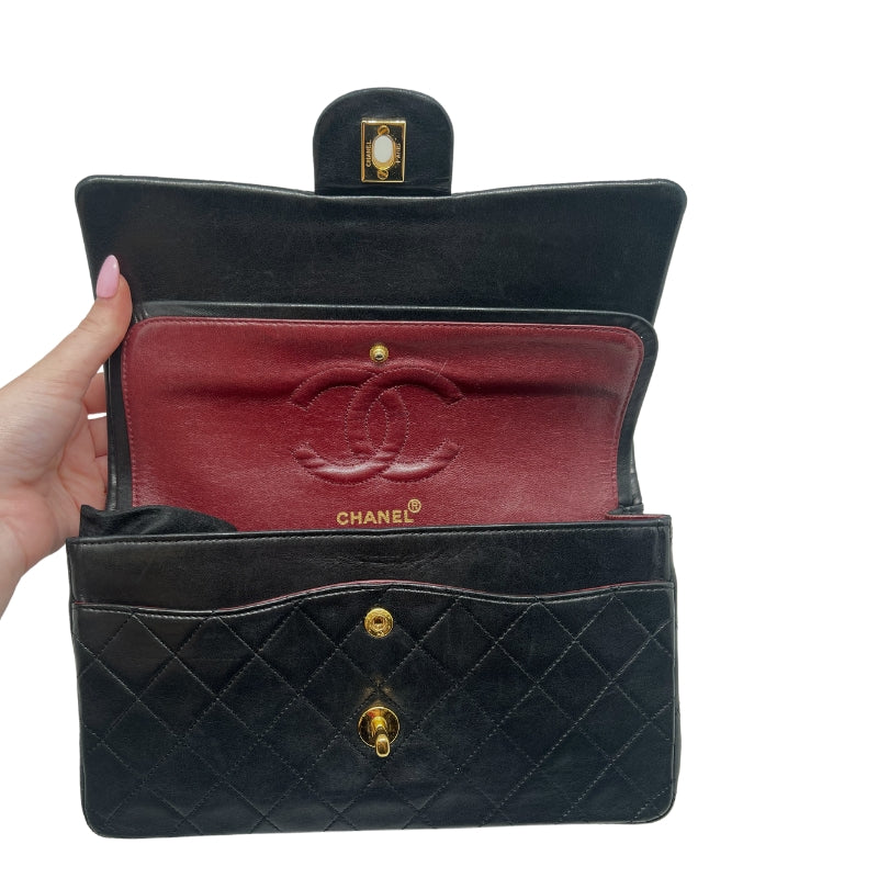 Chanel Double Flap Quilted Shoulder Bag  Black Leather Exterior  Gold Toned Hardware  Gold-Toned Chain-link Shoulder Strap  Single Exterior Back Pocket with Burgundy Leather Interior  Single Black Zipper Under First Flap  Burgundy Chanel Logo Under Second Flap  Three Interior Flat Pockets Under Second Flap