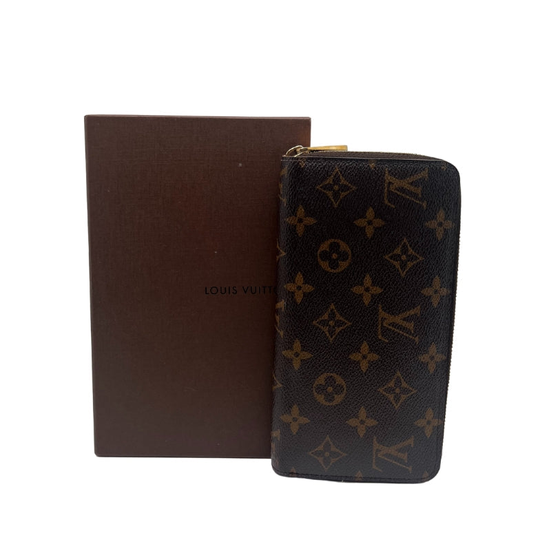 Louis Vuitton Monogram Zippy Wallet  Monogram Canvas Exterior   Gold Toned Hardware   Exposed Zip Closure   Brown Leather Interior   Five Main Interior Pocket Sections   One Zip Closure   Eight Card Pockets