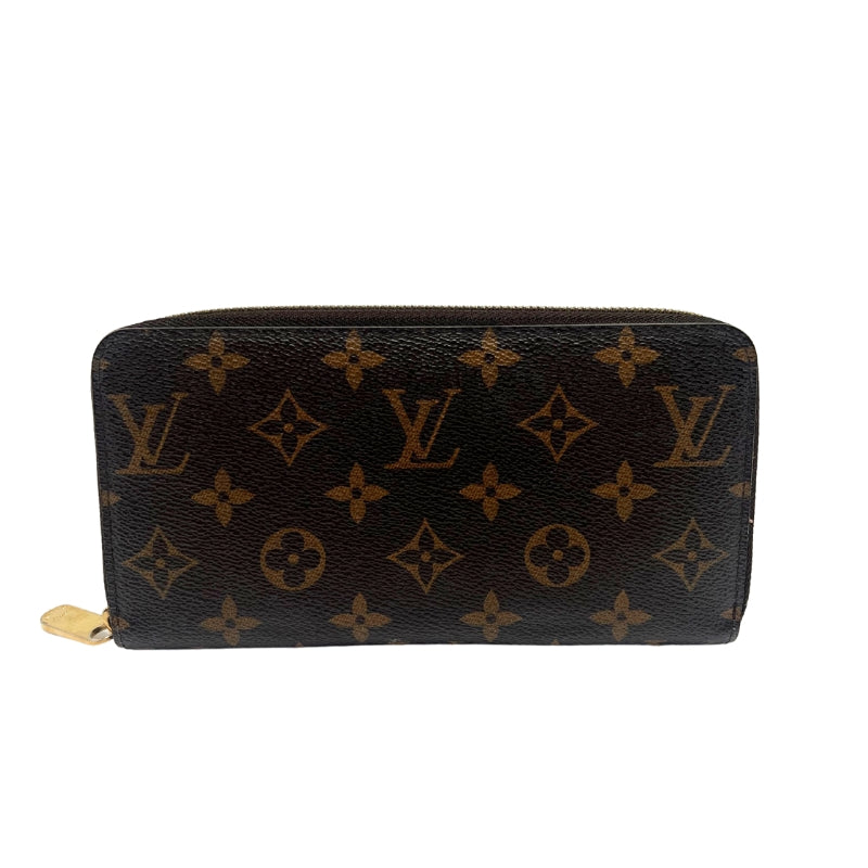 Louis Vuitton Monogram Zippy Wallet  Monogram Canvas Exterior   Gold Toned Hardware   Exposed Zip Closure   Brown Leather Interior   Five Main Interior Pocket Sections   One Zip Closure   Eight Card Pockets