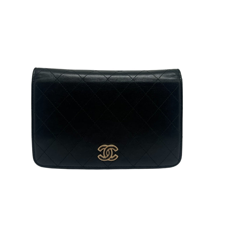Chanel Quilted Chain Wallet  Black Leather Exterior  Gold Toned Hardware   Chanel Monogram Emblem   Single Should Strap   Front Flap Closure with Button  Black Leather Interior   Interior Flat Pocket Attached to Front Flap with Zip Closure  Single Flat Pocket Under Front Flap  Interior Pocket with Zip Closure   Six Interior Card Pockets 