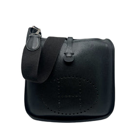 Hermès Evelyne PM Shoulder Bag  Black Leather Exterior   Silver Toned Hardware   Hermès Logo on Front Exterior   Single Fabric Cross Body Strap  Single Exterior Flat Back Pocket  Button Closure on Exterior   Black Suede Interior 