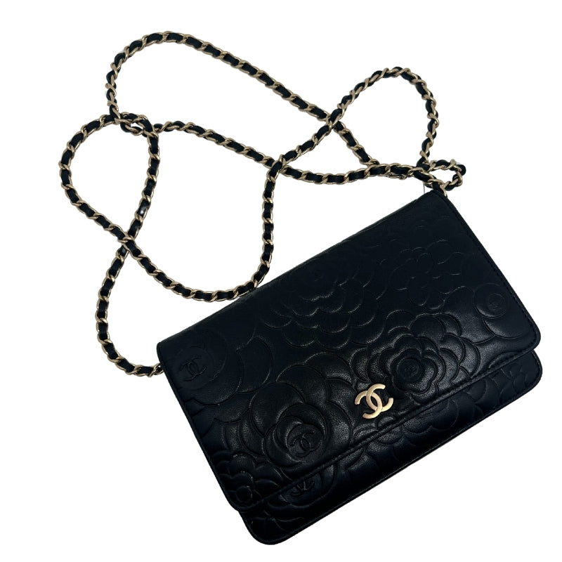Chanel Lambskin Camellia Embossed Wallet on Chain WOC  Black Leather Exterior   Gold Toned Hardware  Flower Embellishments with Chanel Logo on Exterior   Single Chain Strap   Chanel Emblem on Exterior   Frontal Exterior Flap with Button Closure   Two Interior Zipper Pockets  Single Interior Flat Pocket with Black Leather Exterior   Eight Small Flat Interior Pocket   Single Interior Pocket   Cream Fabric Interior 