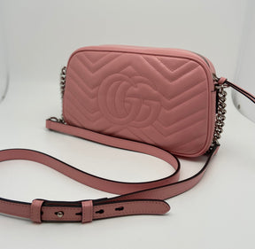 Gucci Marmont Matelassé Pink Crossbody Bag | Pink Leather | GG Logo | Silver-Tone Hardware | GG Logo Stitched on Back | Leather Trim | Adjustable Shoulder Strap | Chain Link Accents | Zip Closure at Top | Single Interior Pocket | Excellent Condition